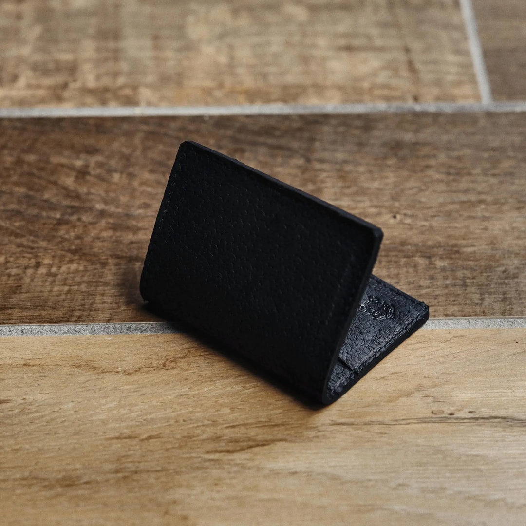 Black leather wallet on a wooden surface
