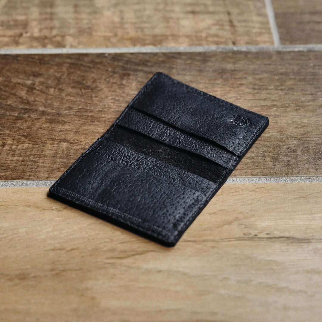 Black leather wallet on a wooden surface