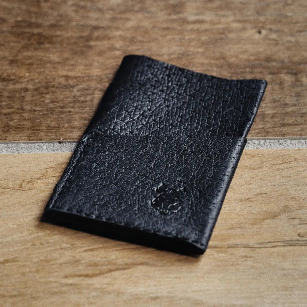 Black leather wallet on a wooden surface
