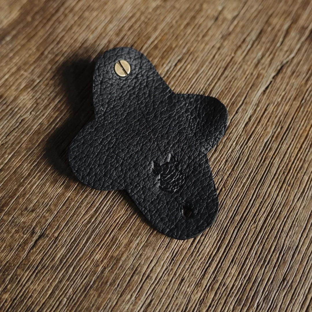 Black jabari boar leather cable wrap on a wooden surface