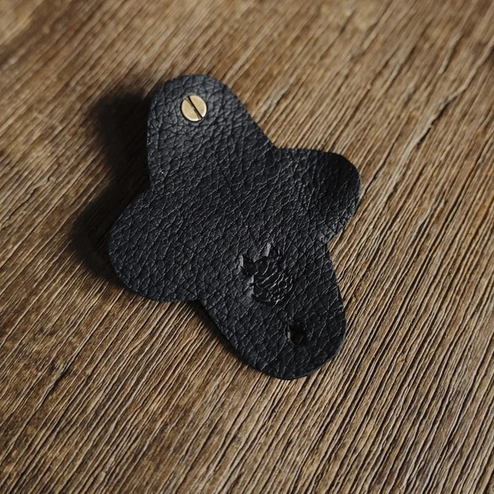 Black jabari boar leather cable wrap on a wooden surface