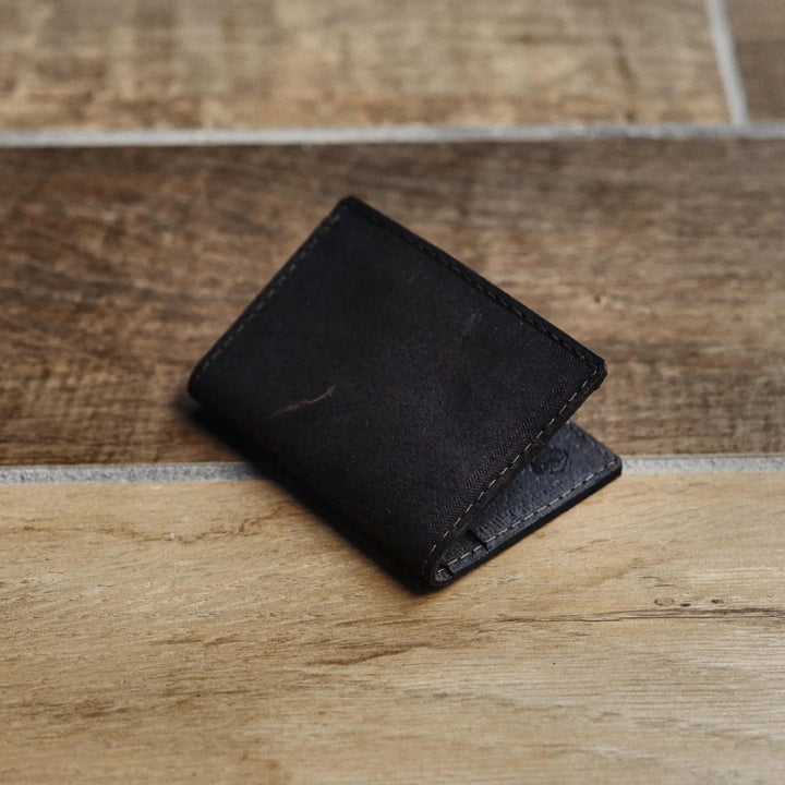 Black leather wallet on a wooden surface