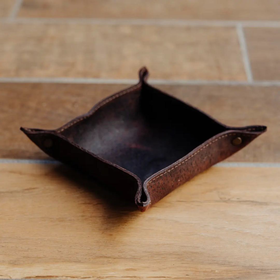 Dark brown boar leather tray on a wooden surface