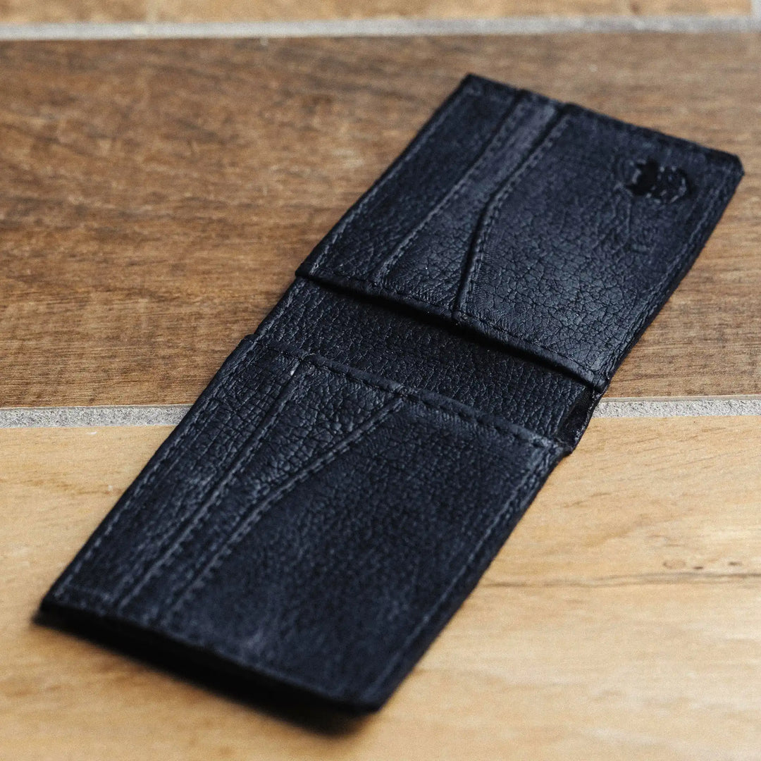 Black leather wallet on a wooden surface