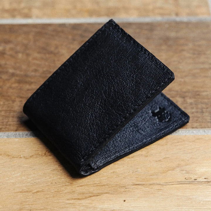 Black leather wallet on a wooden surface