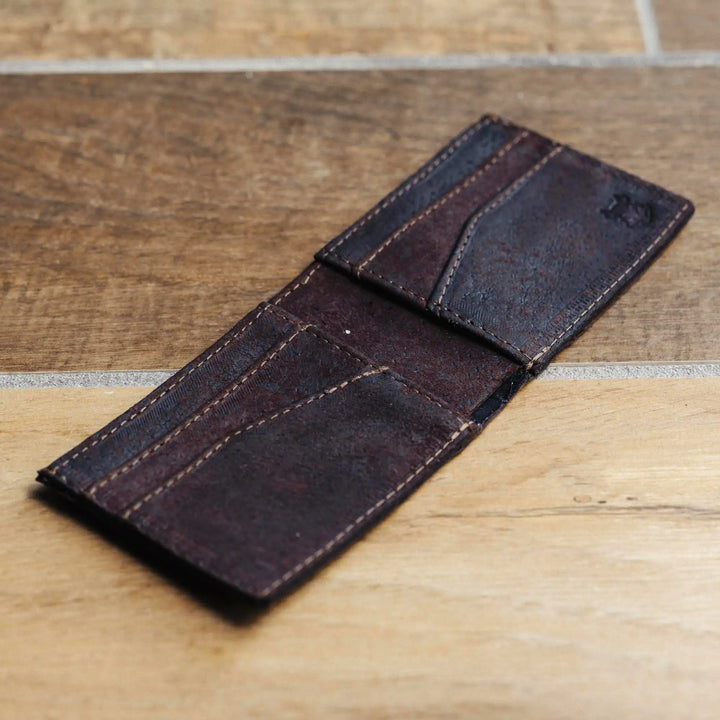 Dark brown leather wallet on a wooden surface