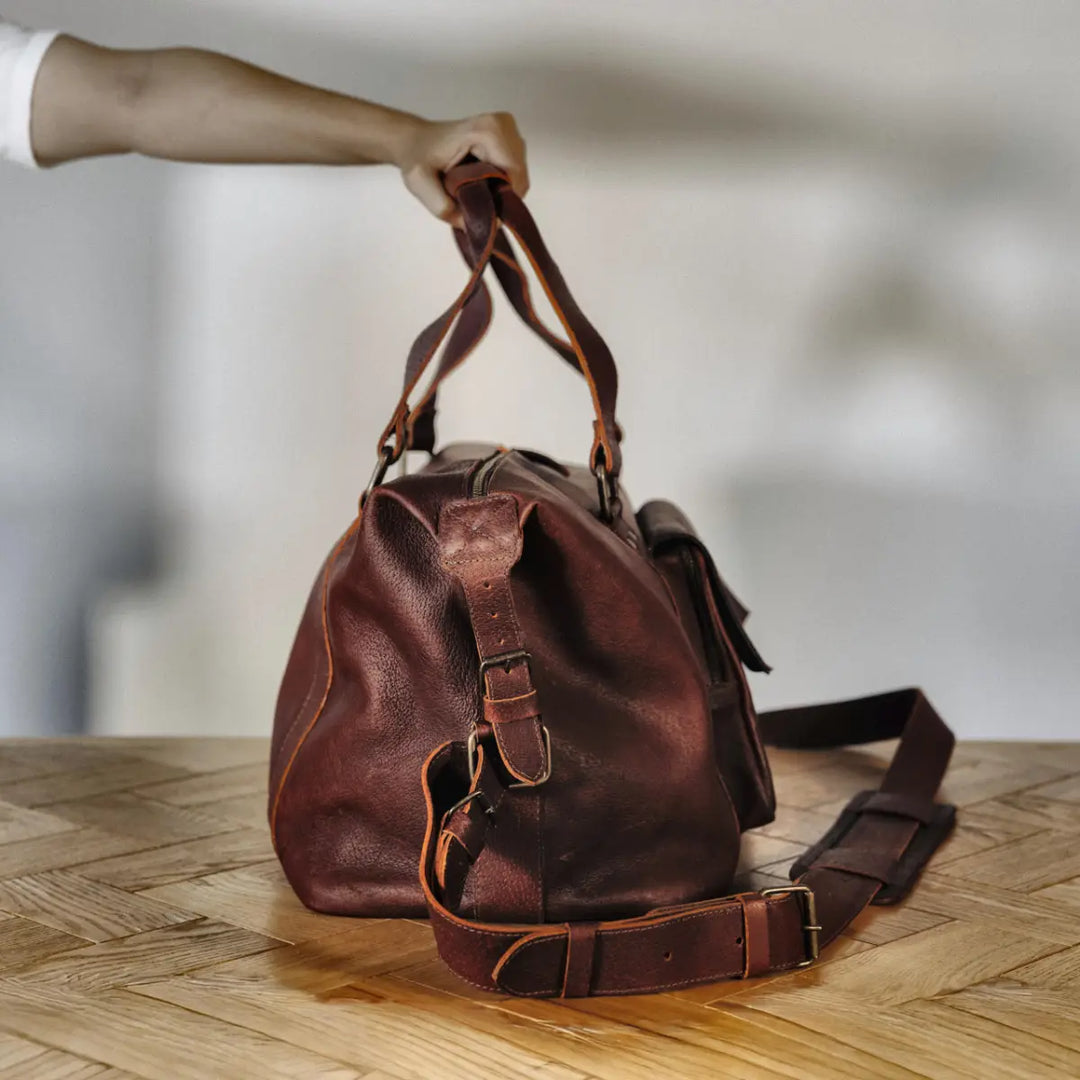 Cognac boar leather bag on a wooden surface with a blurred background