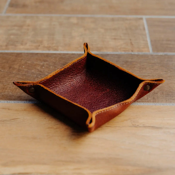Brown boar leather tray on a wooden surface
