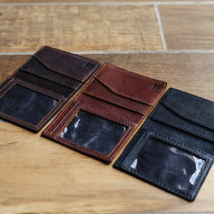 one dark brown, reddish brown, and black leather wallet on a wooden surface