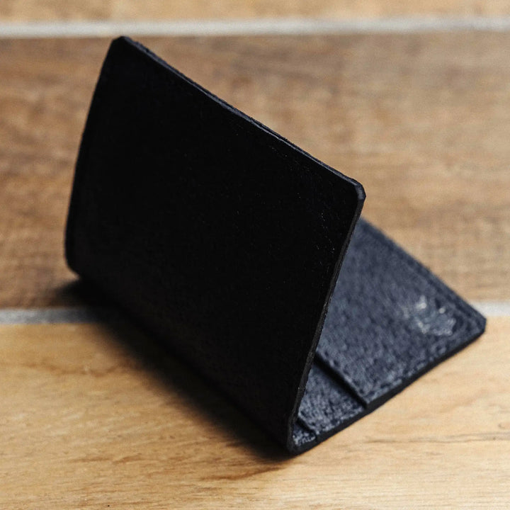 Black leather wallet on a wooden surface
