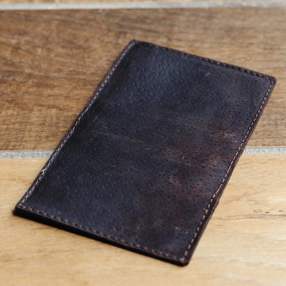dark brown leather wallet on a wooden surface