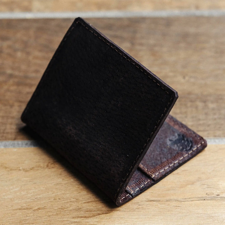 dark brown leather wallet on a wooden surface