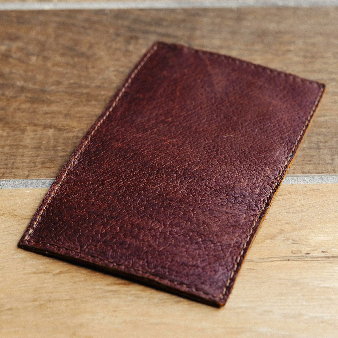 reddish brown leather wallet on a wooden surface